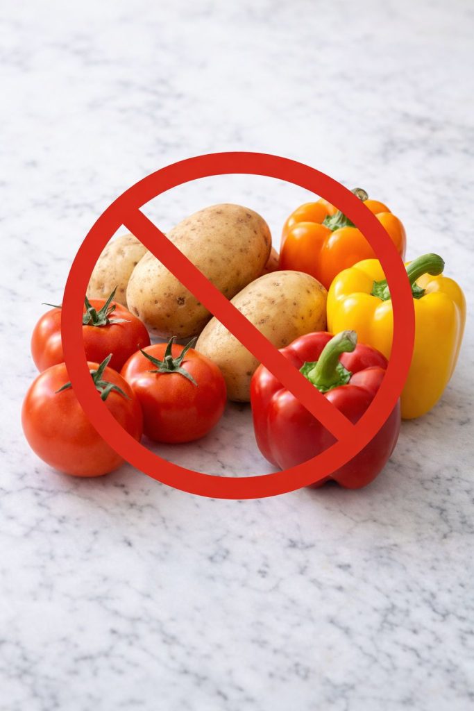 Tomatoes, potatoes, and bell peppers with a crossed-out warning sign, representing nightshade foods to avoid